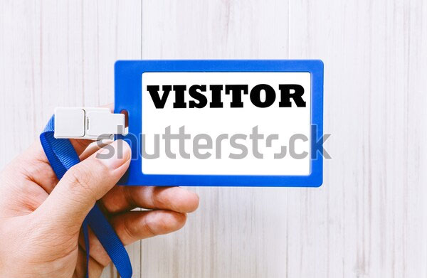 Hand Holding Visitor Pass Tag Card